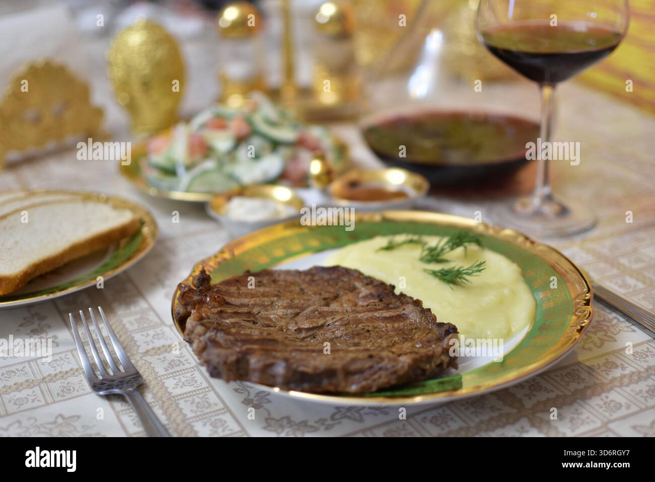 Gegrilltes Steak mit Rotwein in Glaskaraffe und Salate auf Holztisch Stockfoto
