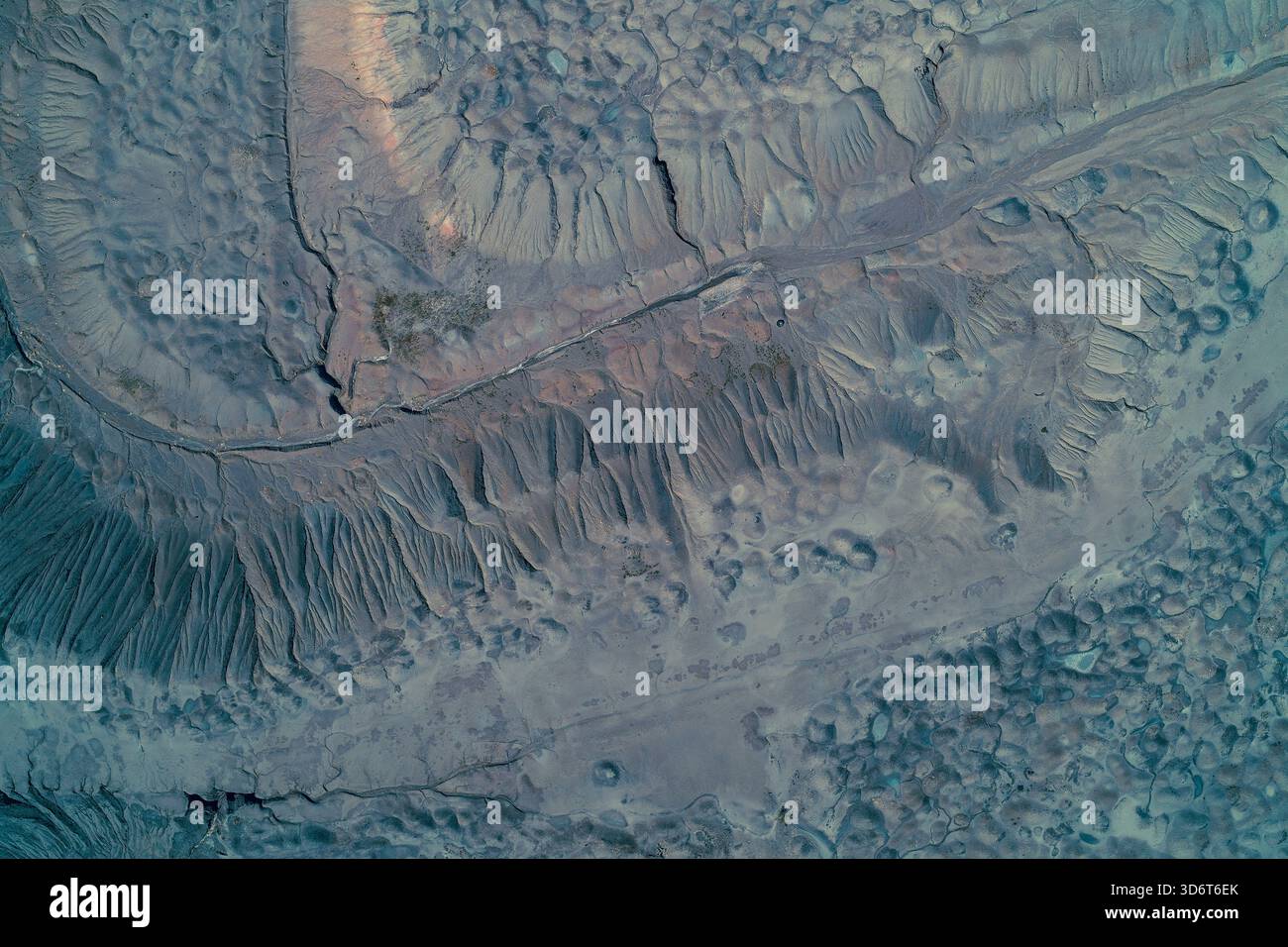 Von oben nach unten auf eine riesige Müllhalde oder Schlackenhaufen. Abstrakte geomorphe Textur mit Blaugrau-Tönen, die starke Erosion, Grate und Bodendegradation zeigen. Stockfoto