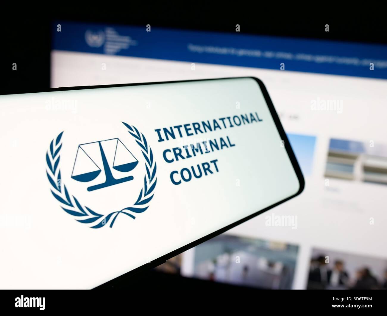 In dieser Abbildung ist ein Smartphone mit dem Logo der Organisation International Criminal Court (ICC) auf dem Bildschirm vor der Website zu sehen. Stockfoto