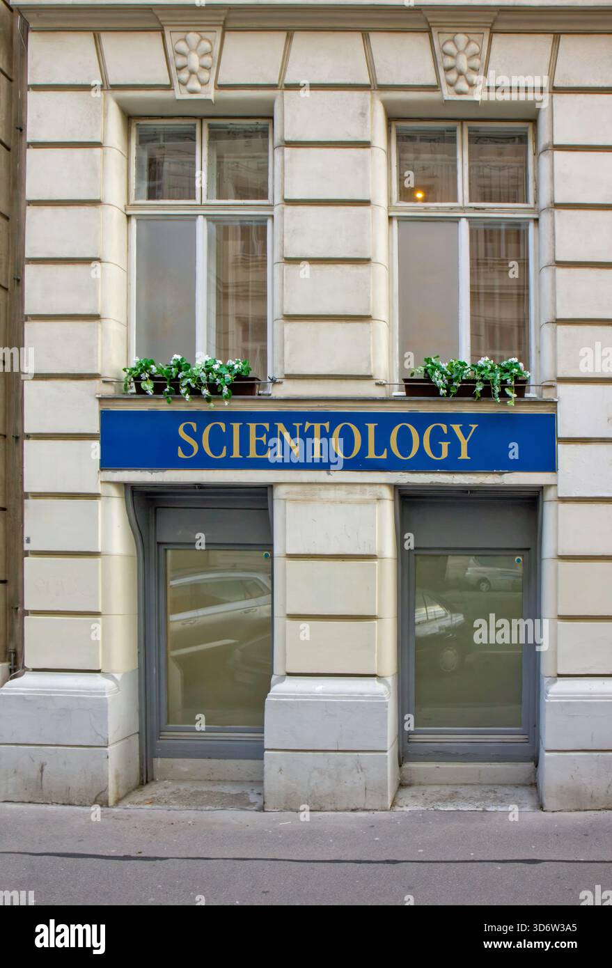 Blaues und goldenes Scientology-Schild im Erdgeschoss einer klassischen Wiener Gebäudefassade Stockfoto