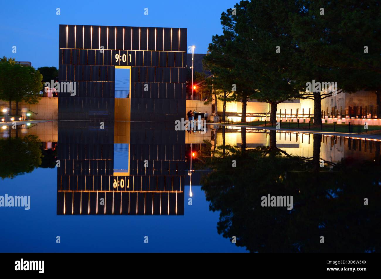 Die Tore mit der Zeit 9:01 Uhr, der Zeit vor dem Terroranschlag in Oklahoma City, Oklahoma, werden nachts beleuchtet und im ruhigen Wasser reflektiert Stockfoto
