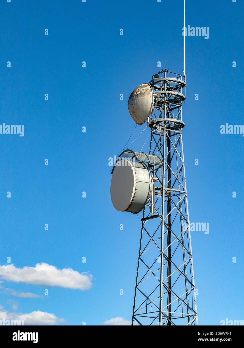 Unmarkierter Mobilfunkmast und Antennen isoliert vor blauem Himmel. Stockfoto