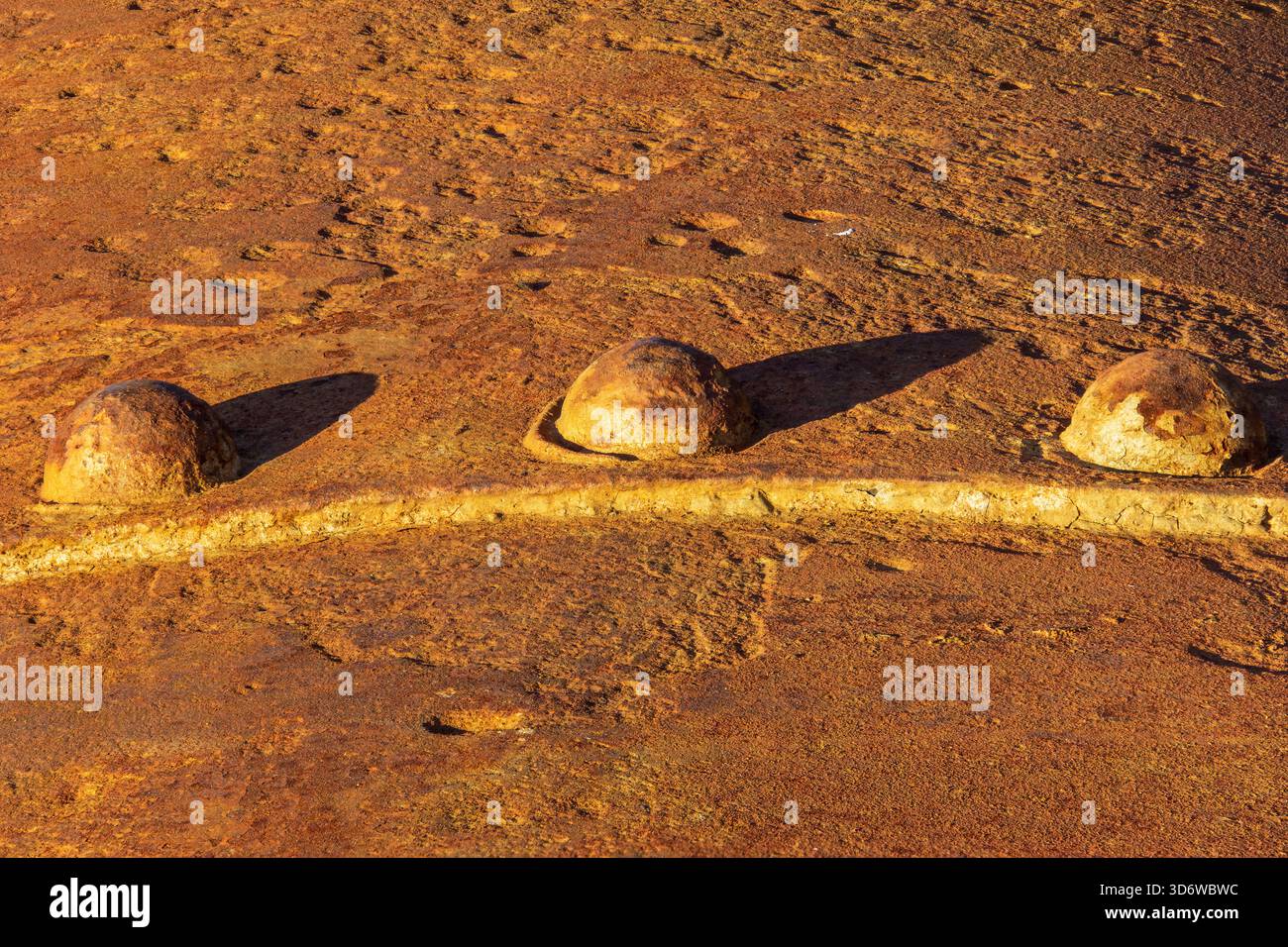 Rostige Metallschrauben auf korrodierter Oberfläche bei warmem Licht, industrielle Makrodetails mit Textur, Patina und Witterung. Stockfoto