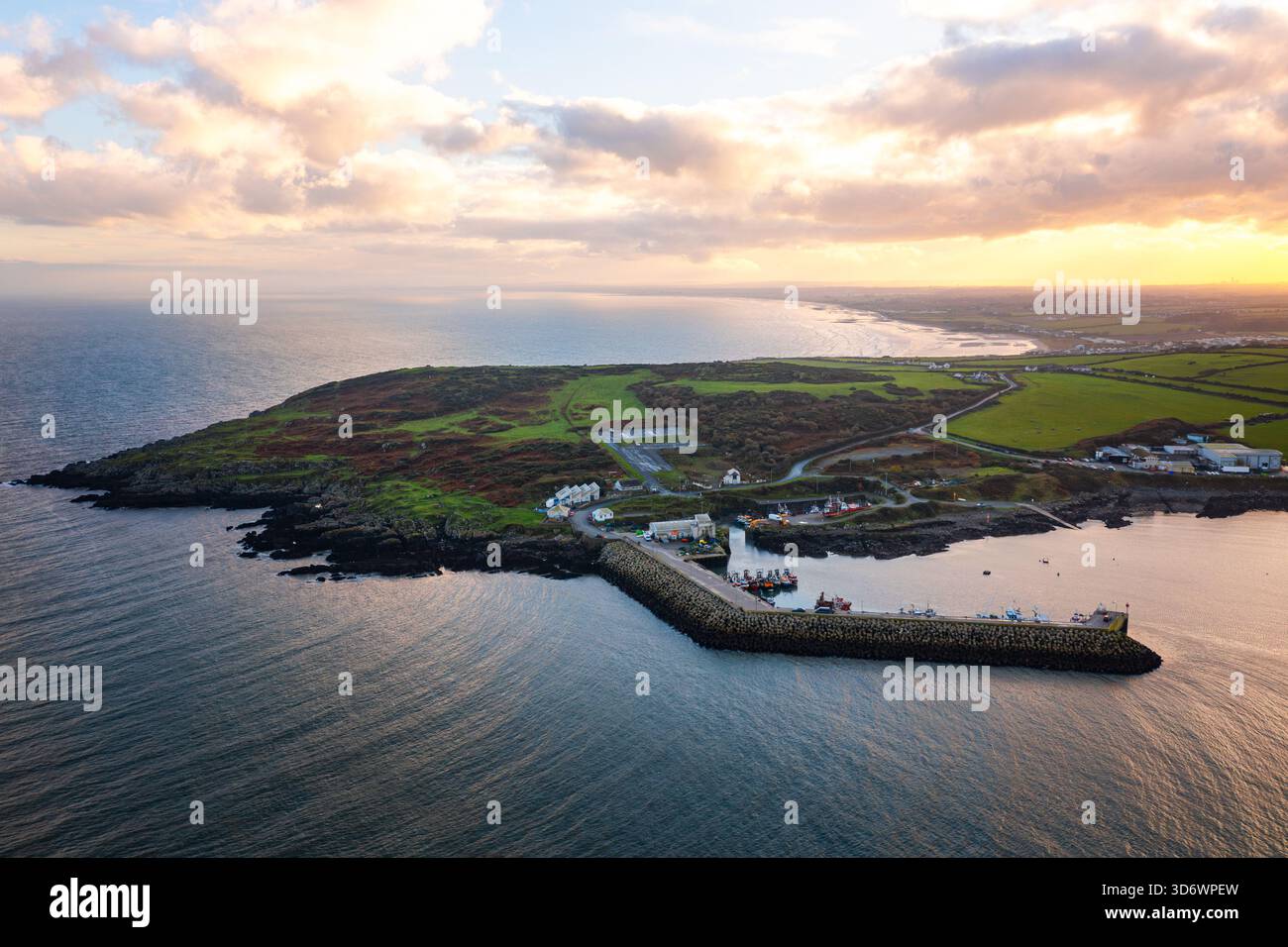 Blick aus der Vogelperspektive auf Port Oriel in Clogherhead mit Fischerbooten und trübem Abendlicht entlang der ruhigen Küste Stockfoto