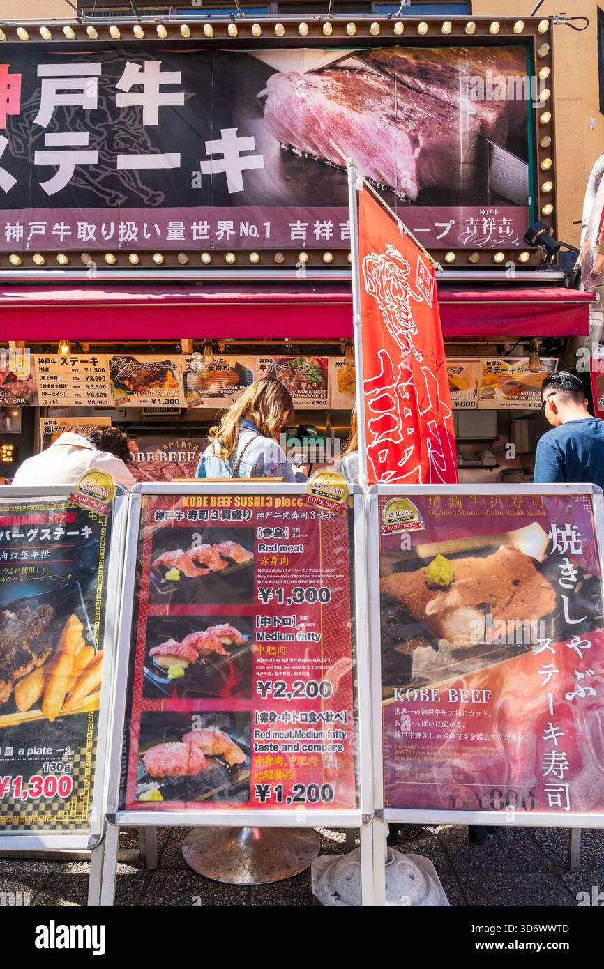 Große Menütafeln für Kobe-Rindfleisch an einem sonnigen Tag vor dem berühmten beliebten Kobe-Beef-Take-away-Schalter an der Ecke des Nankinmachi-Platzes. Stockfoto