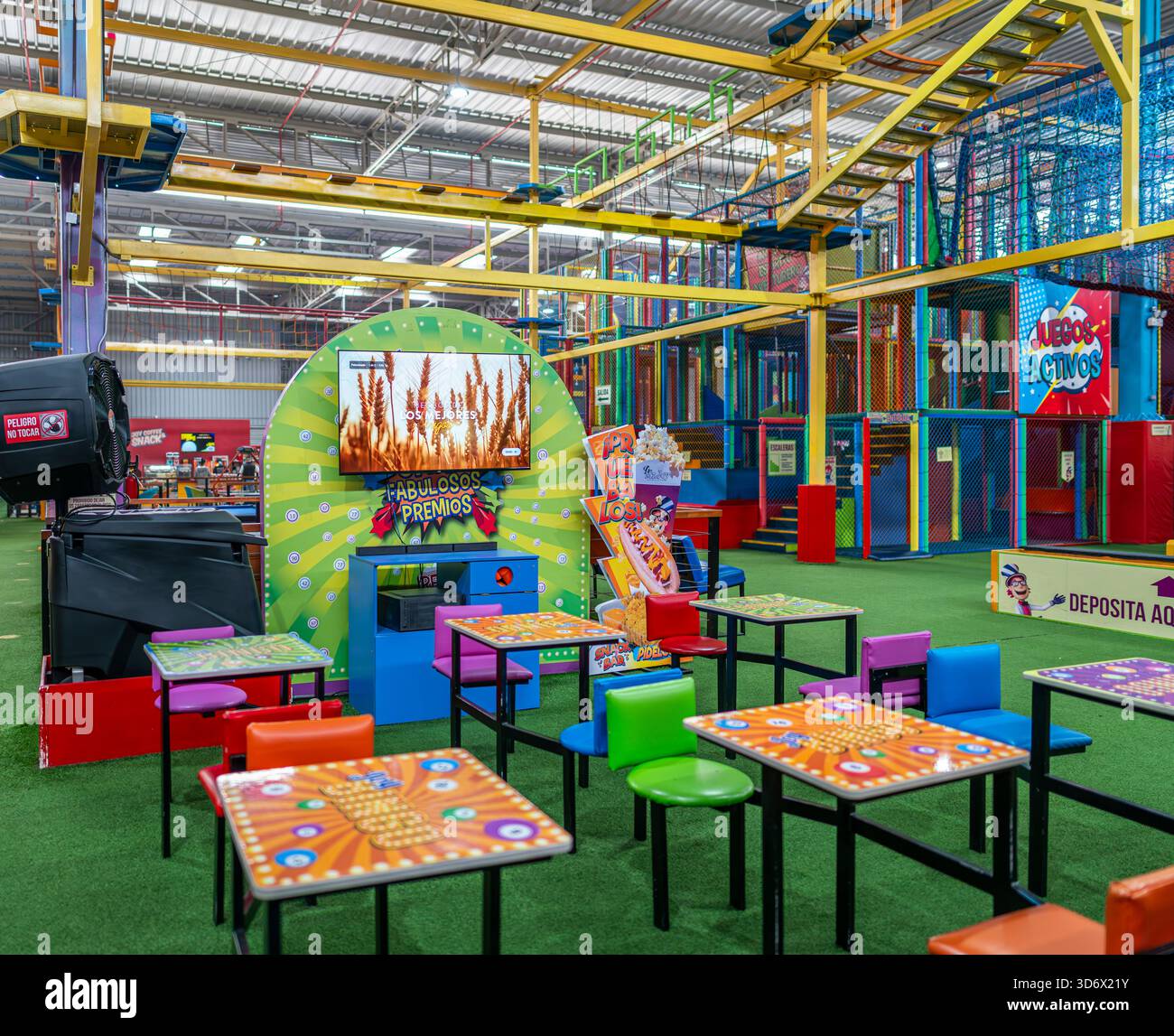 Dokumentarfilm eines Indoor-Kinderaktivitätenzentrums mit farbenfrohen Spielstrukturen, Tischen, Stühlen und interaktiven Spielbereichen. Stockfoto