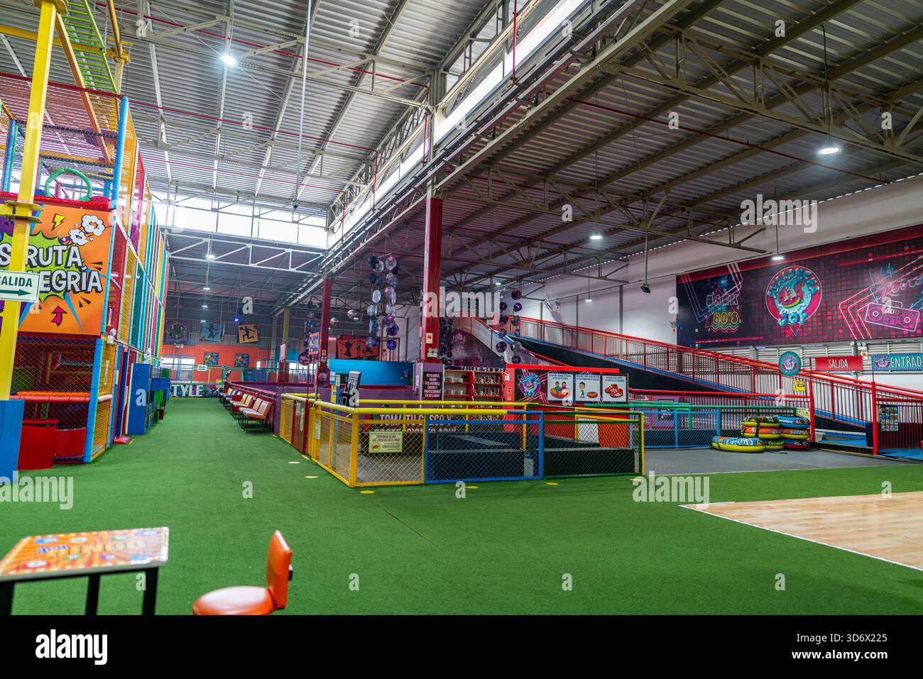 Dokumentaransicht eines Indoor-Kinderaktivitätenzentrums mit aufblasbaren Fahrzonen, bunten Barrieren, Rutschen und Freizeitspielbereichen. Stockfoto