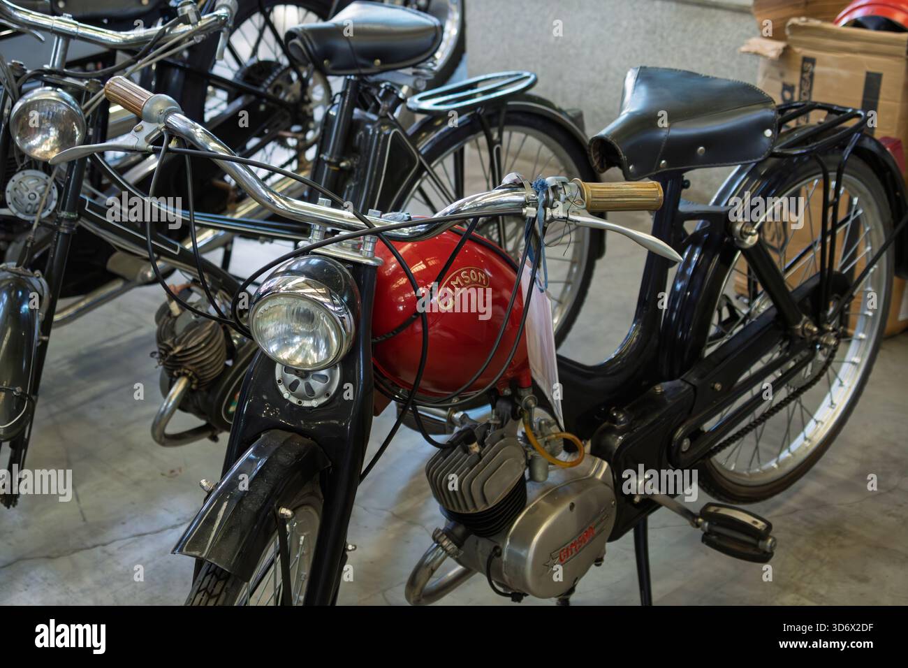 Klassisches deutsches Moped mit rotem Kraftstofftank, schwarzem Rahmen und Chromdetails, das Retro-Stil und Vintage-Technik zeigt Stockfoto