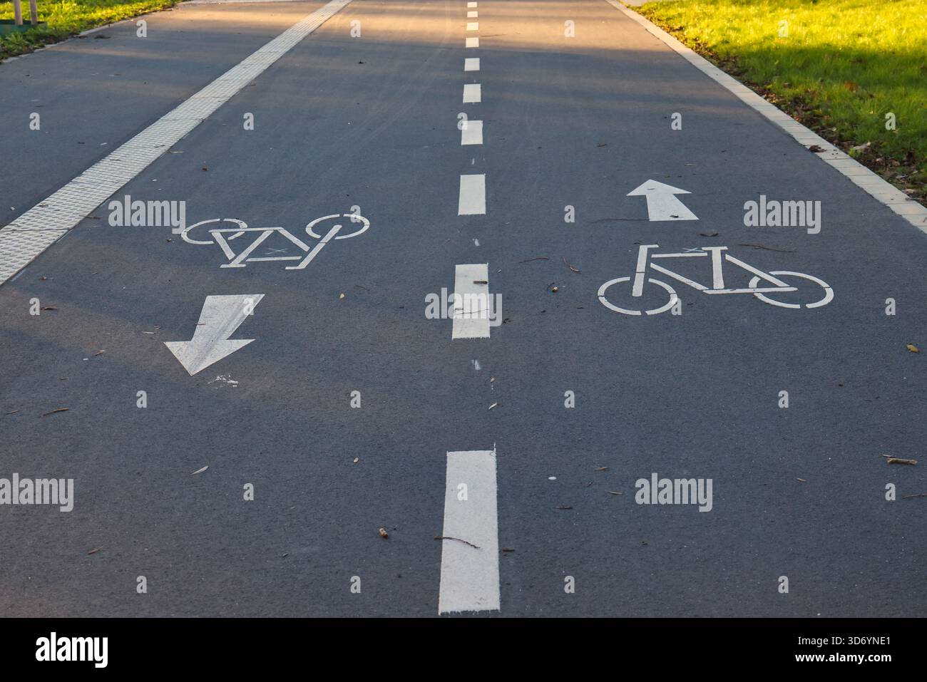 Markierungen auf einem Radweg-Führer in Neuss. Die Sonne scheint auf dieser gut gepflegten Route, die das Radfahren in der Stadt fördert. Stockfoto