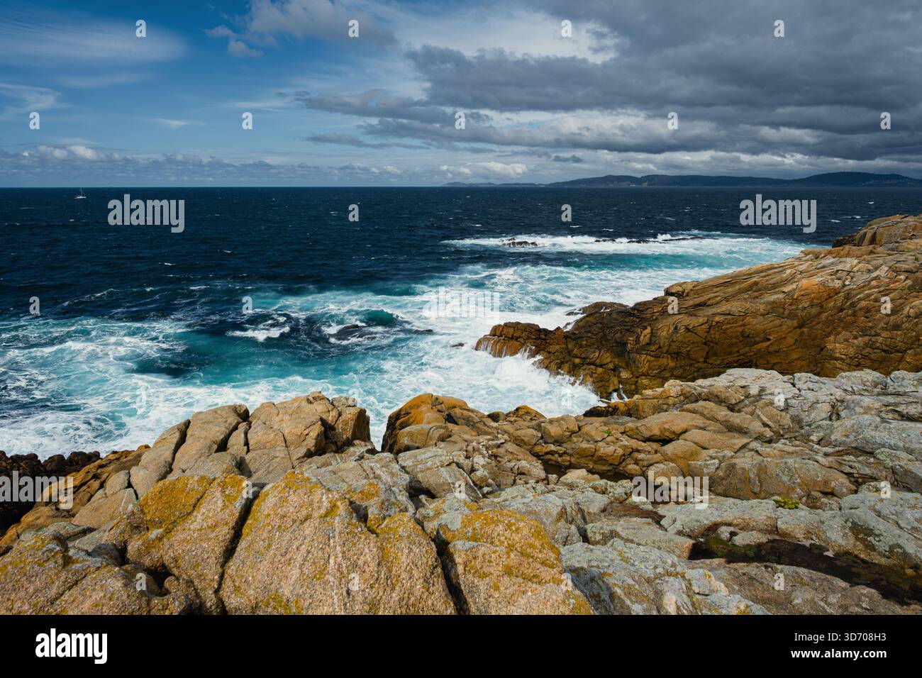 Die Wellen des Atlantiks stürzen gegen die zerklüftete Granitküste eines Vorgebirges und zeigen die dynamische Kraft des Wassers und die wilde natürliche Schönheit. Stockfoto