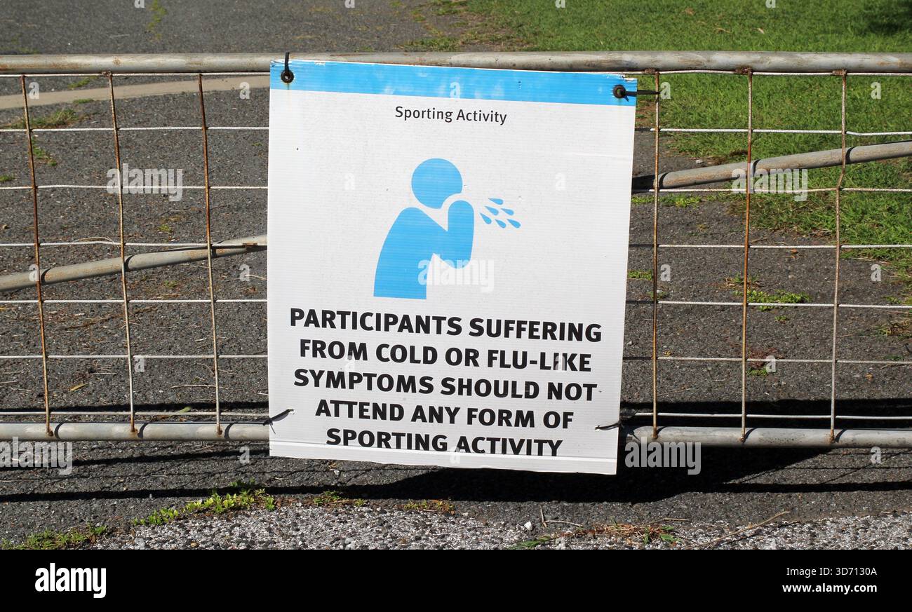„Teilnehmer, die an Erkältungen oder grippeähnlichen Symptomen leiden, sollten an keiner sportlichen Aktivität teilnehmen“, das an einem Metallzaun angebracht ist Stockfoto