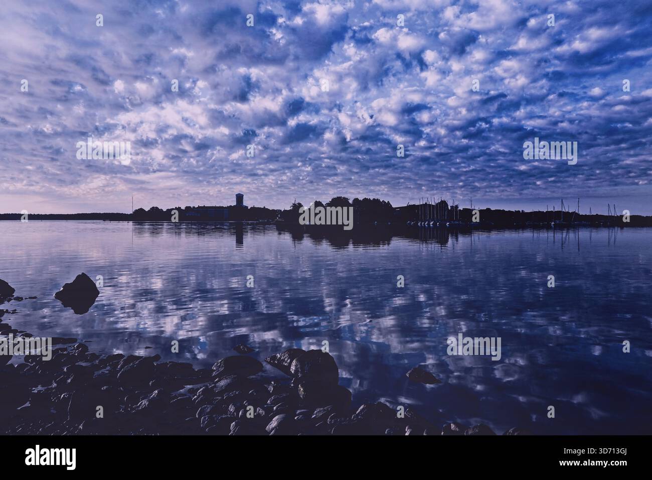 Blick auf die Inseln Särkkä und Suomenlinna an einem ruhigen Sommermorgen mit Wolken, die sich auf der Wasseroberfläche spiegeln. Blauer Ton. Helsinki, Finnland. Stockfoto