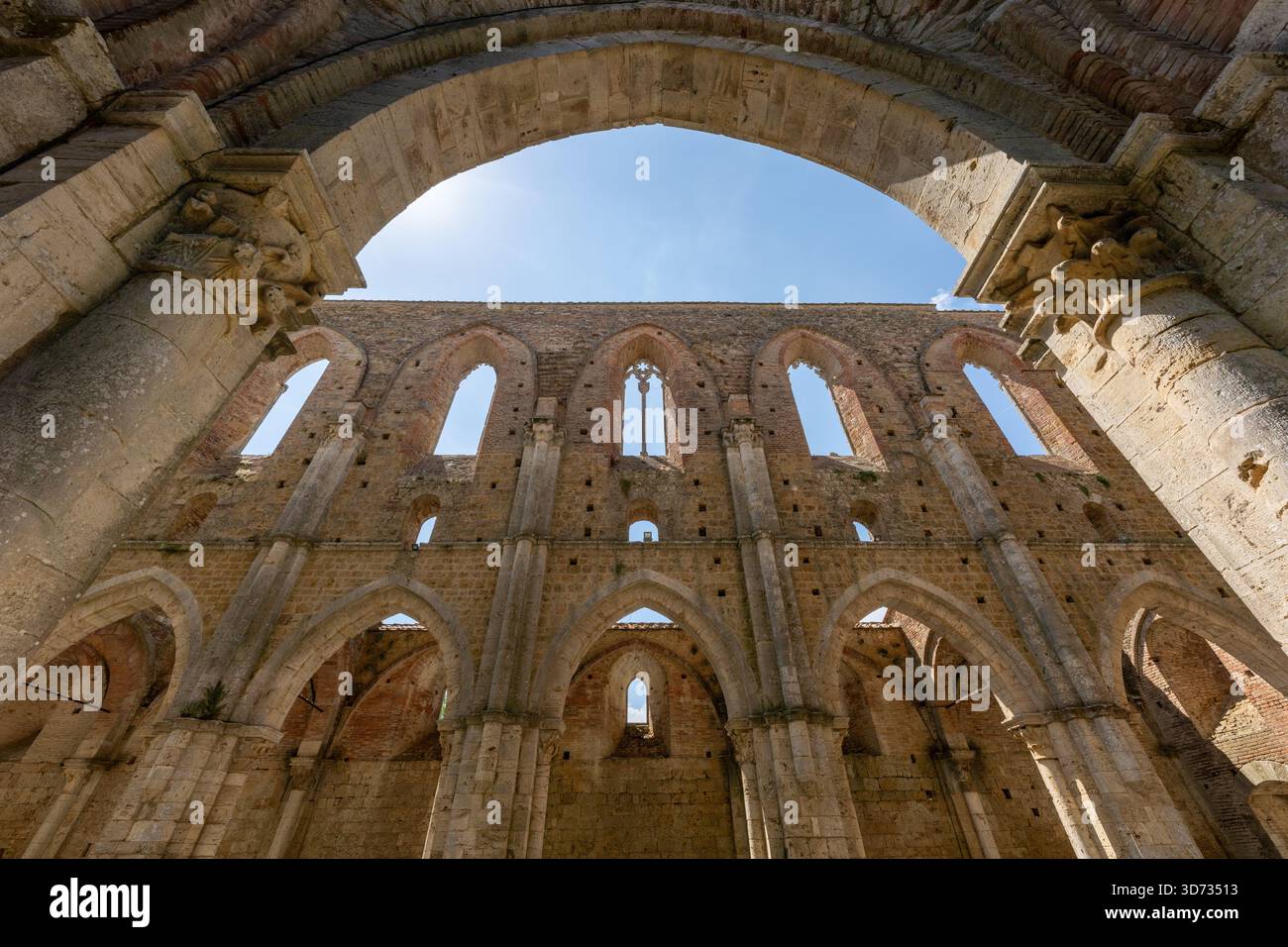 Innenliegende Spitzbögen der dachlosen Zisterzienserabbazia di San Galgano, gotische Klosterruinen aus dem 13. Jahrhundert in der Nähe von Chiusdino in der Toskana. Stockfoto