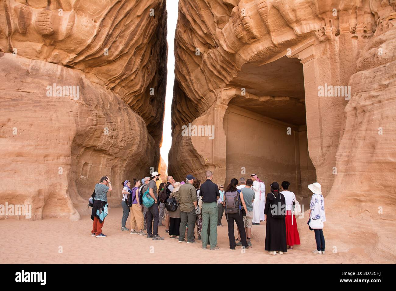 Al Ula, Saudi-Arabien - 23. April 2025: Touristen hören einem arabischen Fremdenführer zu, der Nabatäische Gräber im UNESCO-Hegra-Park erklärt Stockfoto