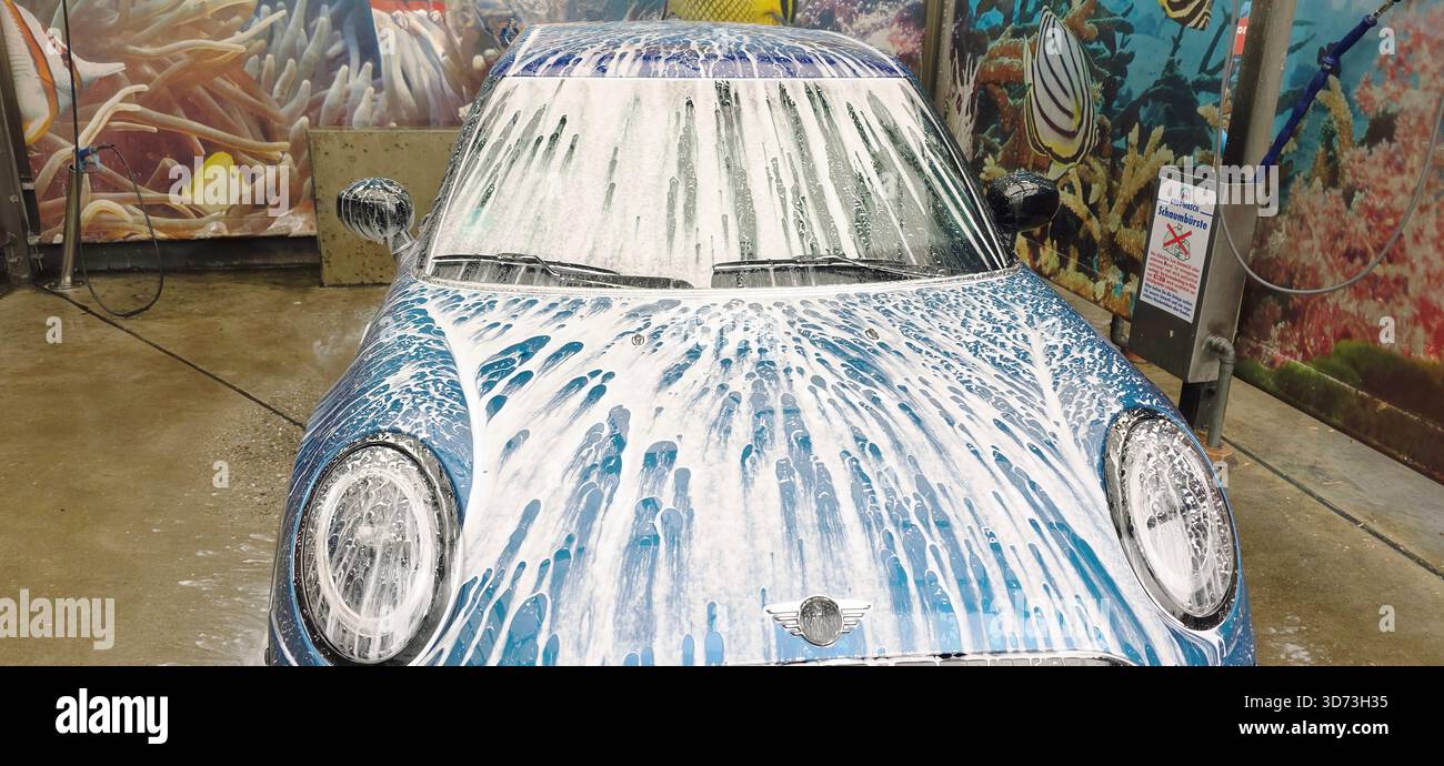 Berlin, Deutschland - 18. Mai 2025: Mini Cooper wird mit Schaum in einer automatischen Autowaschanlage gewaschen. Stockfoto