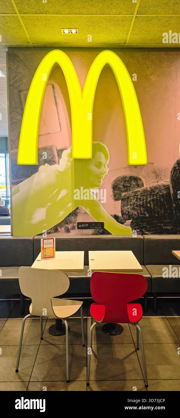 Berlin, Deutschland - 14. Juli 2025: McDonald's Innenraum verfügt über berühmte gelbe Bögen und eine moderne Sitzanordnung. - Smartphone-aufgenommenes Stockfoto
