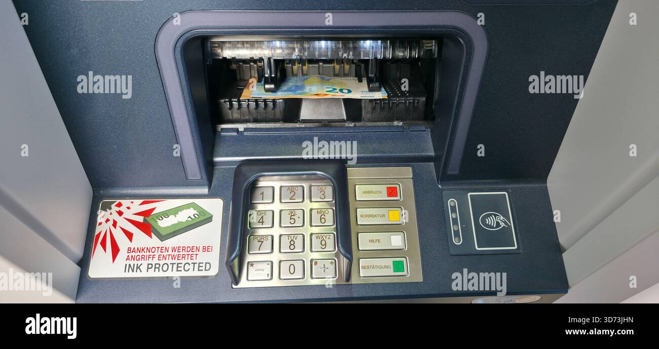Berlin - 23. August 2025: Geldautomat gibt Bargeld mit sichtbarer Banknote und Tastatur im Vordergrund aus. - Smartphone-aufgenommenes Stockfoto