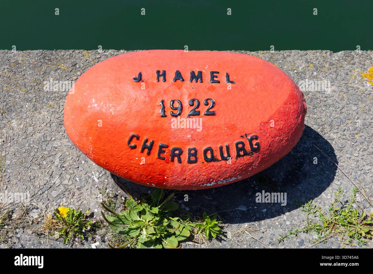 Ein orangener handbemalter Schiffspoller im Hafen von Cherbourg-en-Cotentin (Manche) in der Normandie, Frankreich Stockfoto