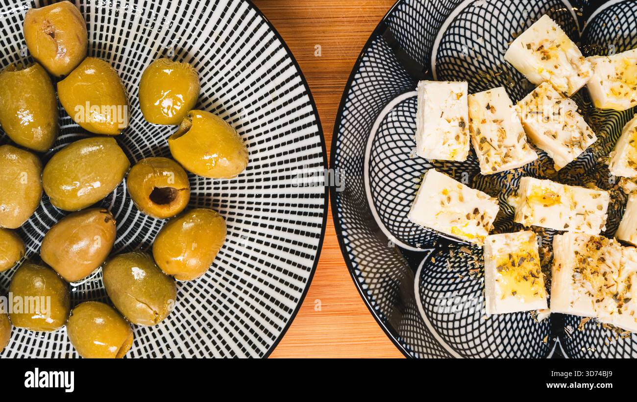 Wunderschöne Anordnung von gemischten Oliven und verschiedenen Käseportionen auf Holzbrett. Die perfekte Vorspeise im mediterranen Stil für Unterhaltung und Unterhaltung Stockfoto