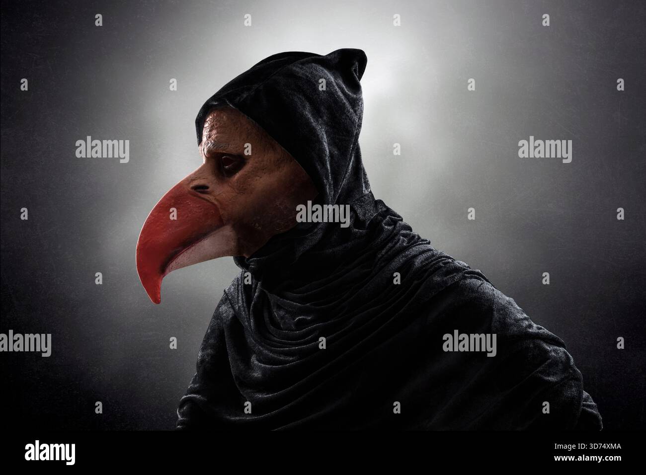 Gruselige Figur mit langem Vogelschnabel in Kapuzenmantel über dunklem nebeligem Hintergrund Stockfoto