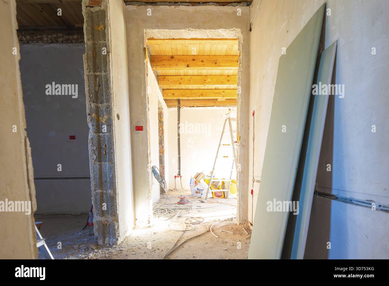 Bausituation in einem Raum mit unfertigen Wänden und Decken. Das Tageslicht strömt herein Stockfoto