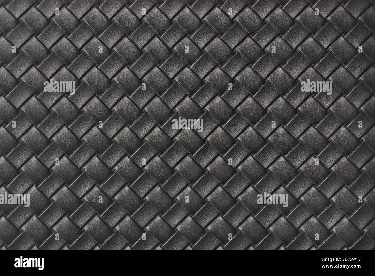 Nahaufnahme aus schwarzem gewebtem Leder, einheitliches diagonales Korbmuster im Vollformat, Hintergrund oder Hintergrund aus luxuriösem synthetischem Material Stockfoto