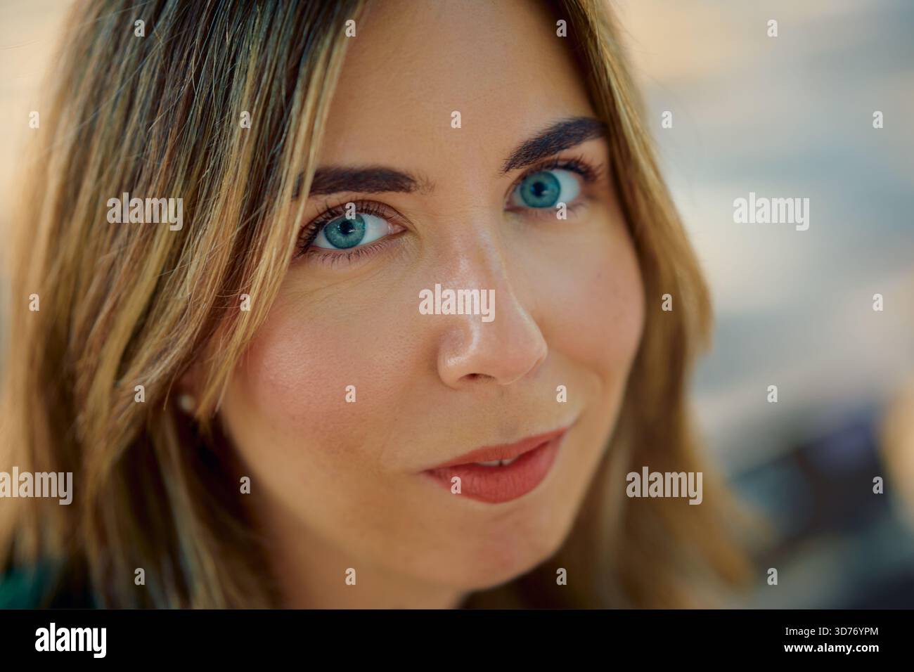 Frau mit blonden Haaren und auffälligen blauen Augen, die lächeln Stockfoto