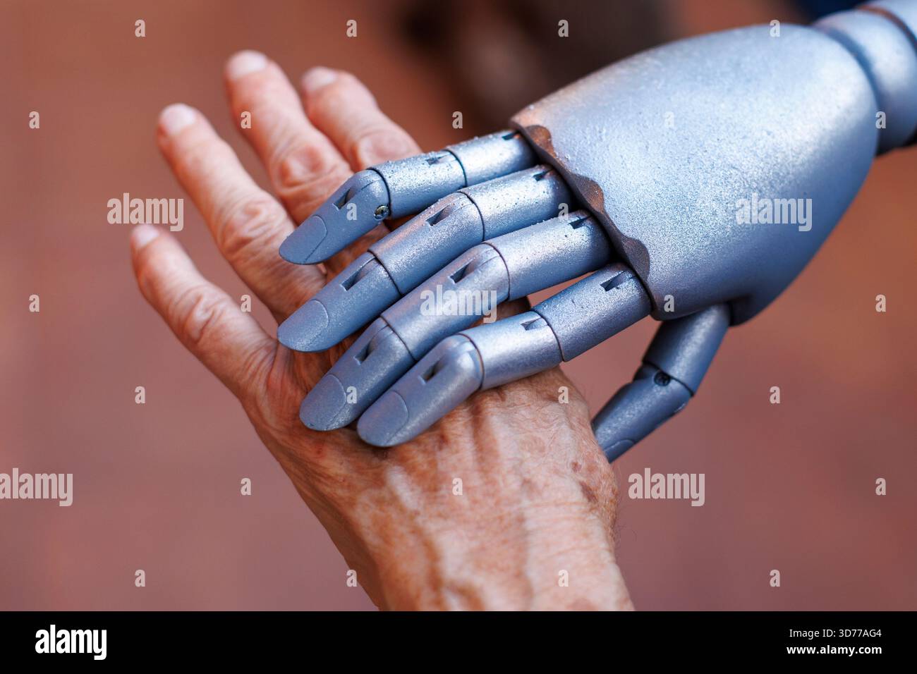Roboterhand, die die Hand der alten Frau hält Stockfoto