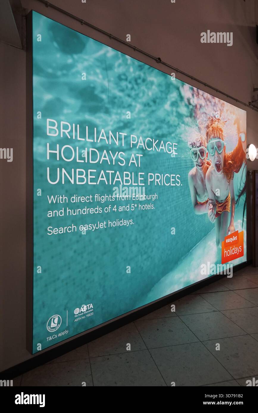 Beleuchtete Werbeplakate für Urlaubsangebote in der Werbung des Flughafens Edinburgh ab Schottland. Edinburgh, Schottland Stockfoto