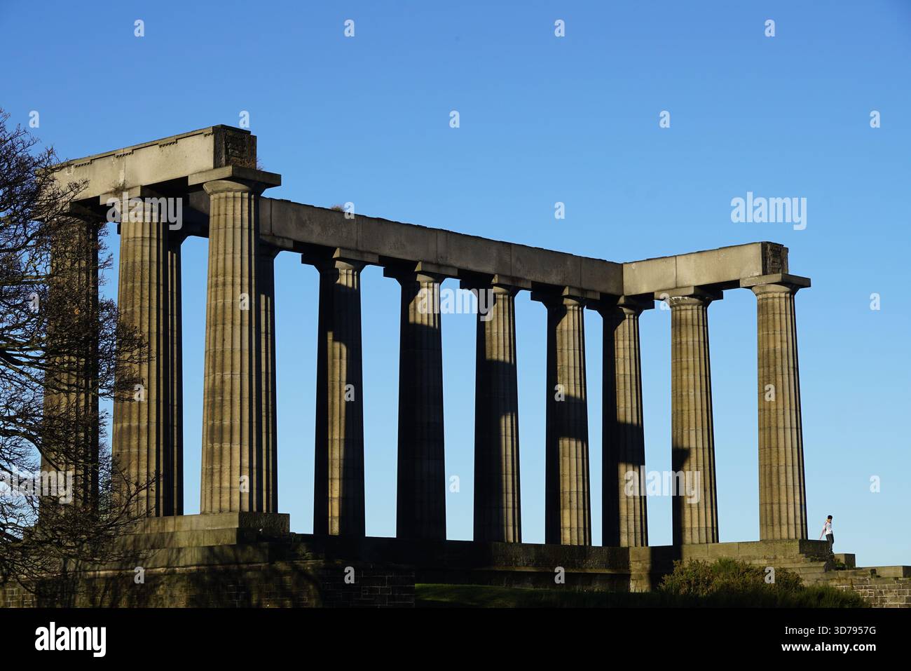 Das National Monument auf dem Calton Hill in Edinburgh, ein neoklassizistisches Wahrzeichen mit hohen Steinsäulen unter einem klaren blauen Himmel. Edinburgh, Schottland Stockfoto
