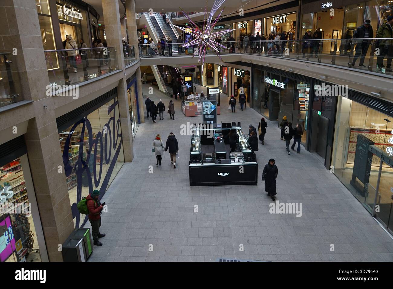 Innenblick auf ein modernes Einkaufszentrum mit mehreren Etagen, Geschäften und dekorativer Beleuchtung. Edinburgh, Schottland Stockfoto
