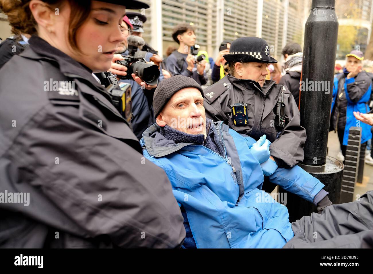 London, Großbritannien. November 2025. Anhänger, die sich für die Aufhebung der Direktaktionsgruppe Palästina-Aktion einsetzen, versammeln sich vor dem Innenministerium mit Schildern, die darauf stehen: "Ich lehne Völkermord ab/ich unterstütze die Palästinensische Aktion", und werden von wartenden Polizeibeamten verhaftet. Verteidigung unsere Geschworenen haben eine Reihe von "Aufhebung des Verbots"-Protesten vor der gerichtlichen Überprüfung gegen das Verbot organisiert, das vor dem Obersten Gerichtshof verhandelt wird. Nach dem heutigen Vorgehen wurden rund 50 Menschen in Gewahrsam genommen. Quelle: Eleventh Photography/Alamy Live News Stockfoto