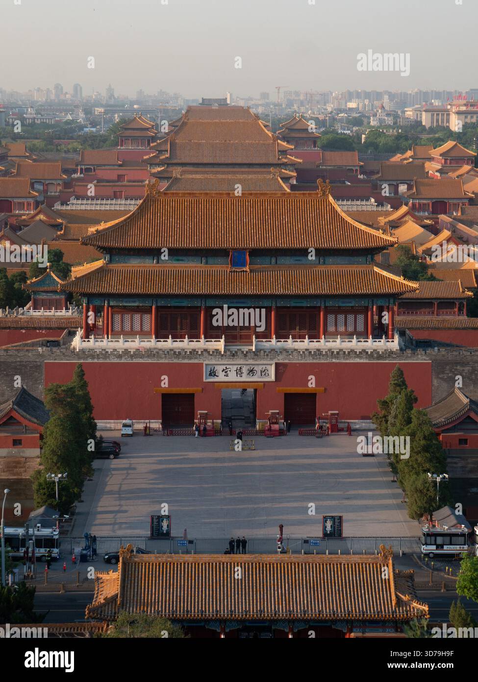 Der Blick auf die majestätische, symmetrische Architektur mit ihren orangen Dächern und roten Wänden steht in krassem Kontrast zur entfernten Skyline der Stadt, Peking, Beij Stockfoto