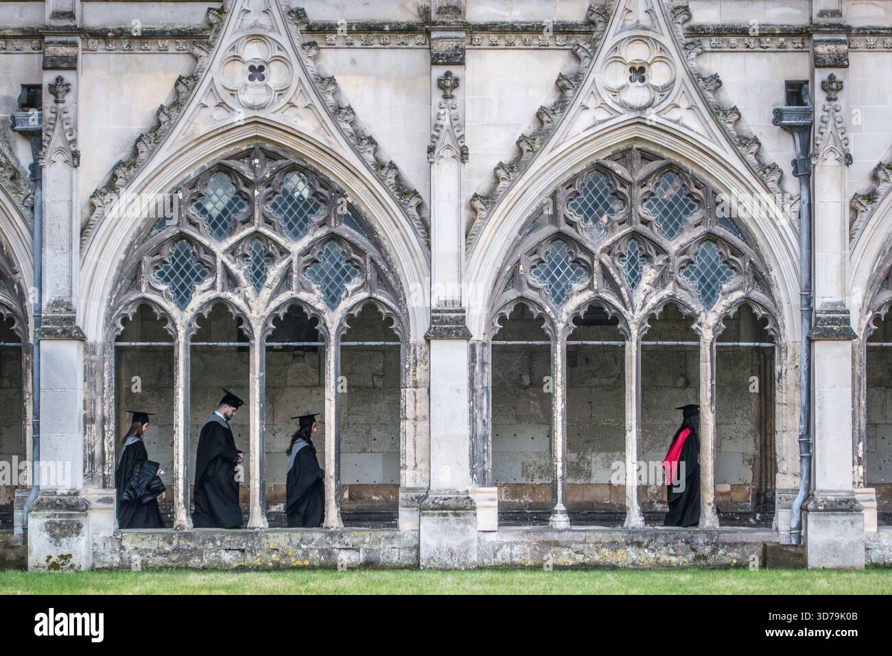 Studenten der Universität von Kent machen sich ihren Weg durch die Kreuzgänge der Kathedrale von Canterbury für ihre Abschlussfeier Ende November (Kent, Großbritannien). Traditionell tragen sie Kleider und akademische Mützen oder Mortarboards Stockfoto