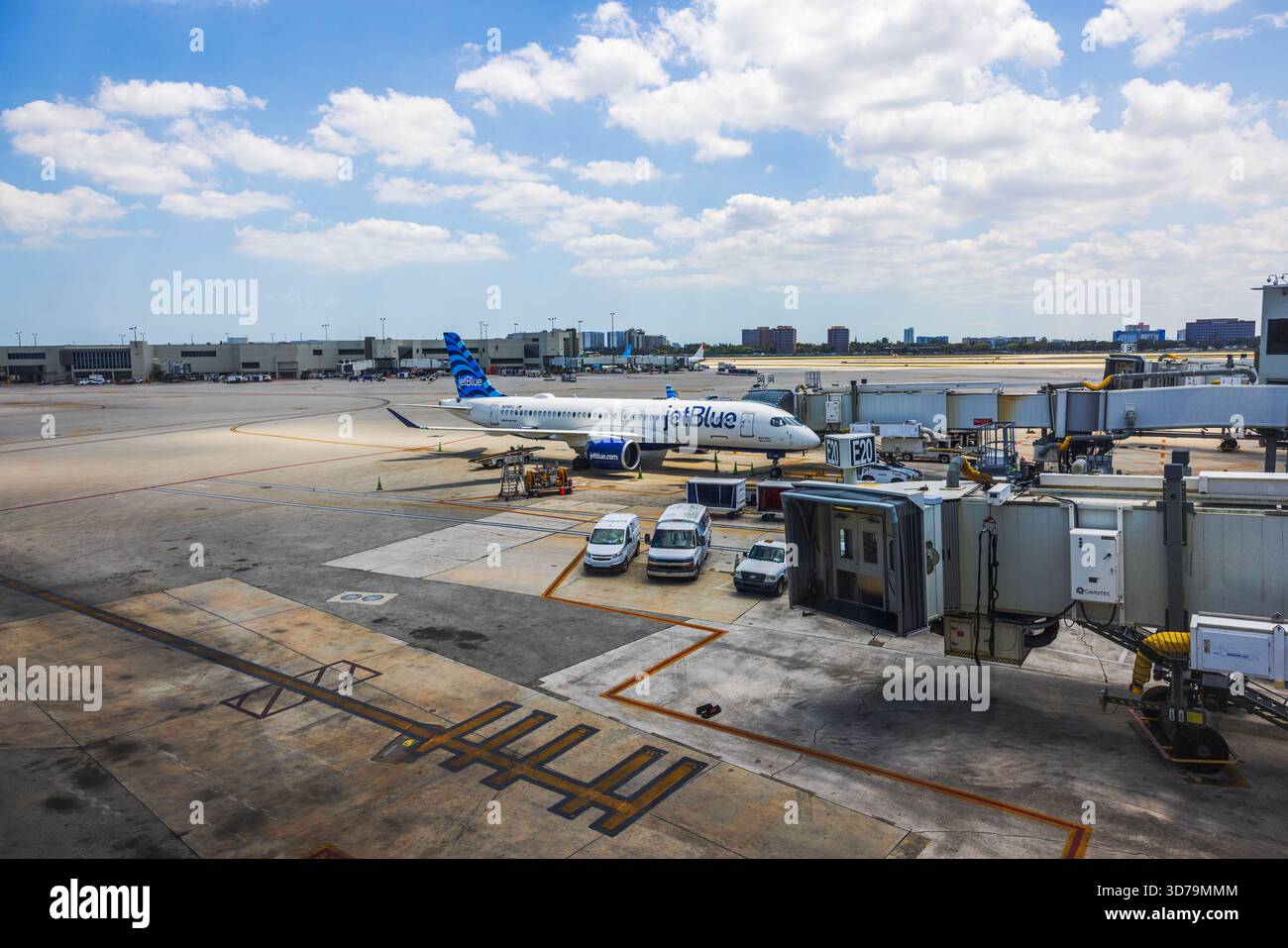 Wunderschöner Blick auf das Jet Blue Flugzeug, das am Flughafentor mit Service Fahrzeugen und Jet Bridge geparkt ist. Miami. USA. Stockfoto