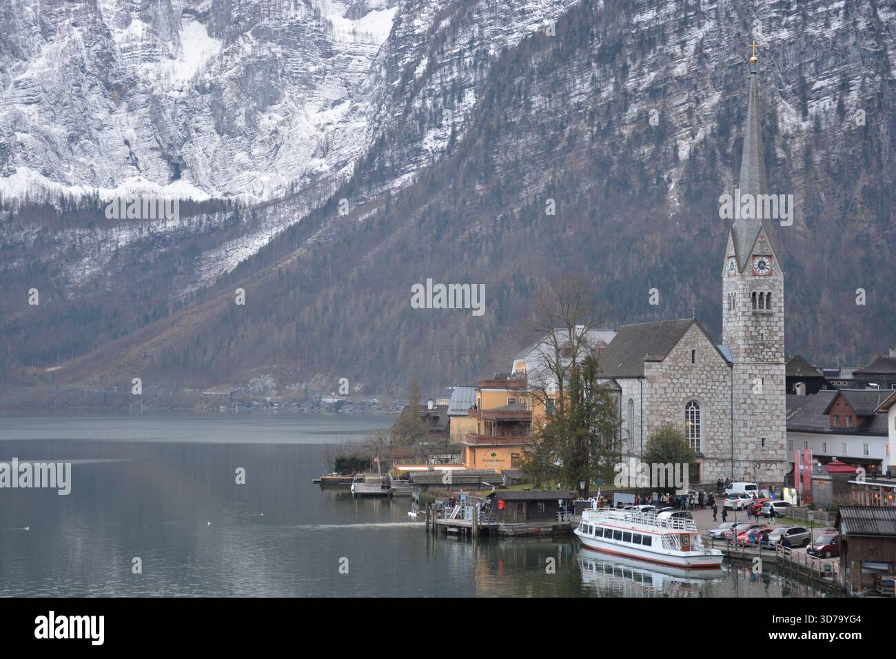 Das Bild zeigt einen klassischen Blick auf Hallstatt, Österreich, mit einer kleinen Kirche am See mit einem hohen Spitzturm. Stockfoto
