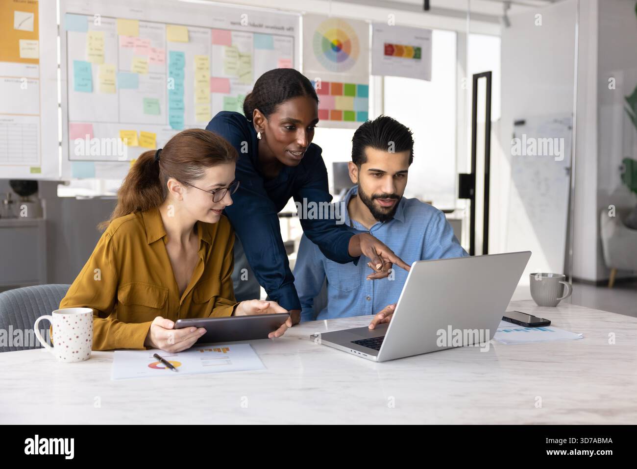 Ein Team von positiven, vielbeschäftigten Fachleuten, die sich Werbemedieninhalte ansehen Stockfoto