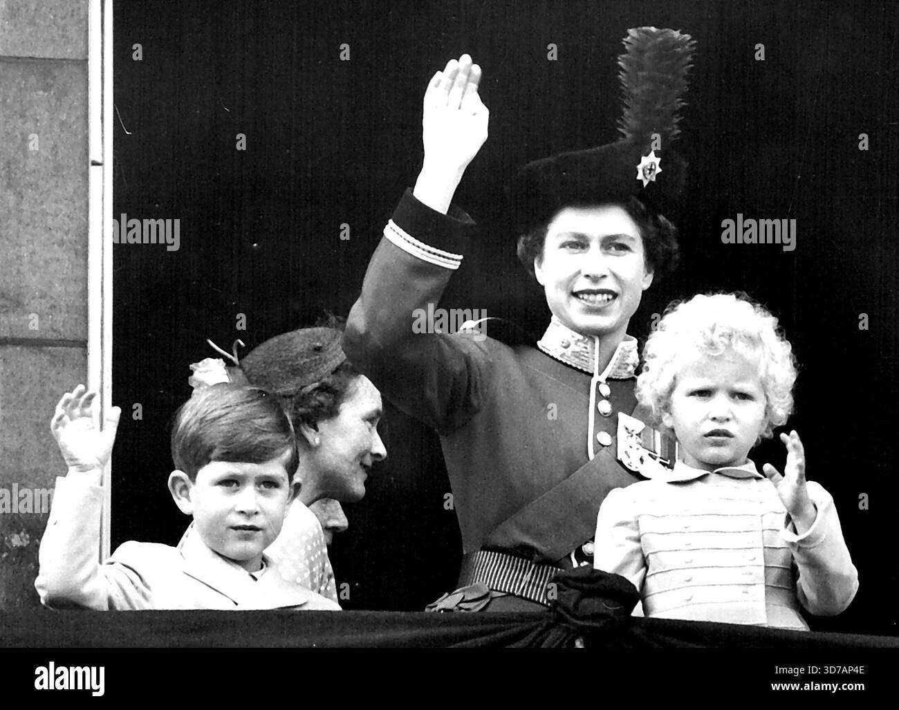 Königin und Kinder winken vom Balkon nach „Trooping“ - die Königin, Prinz Charles und Prinzessin Anne winken vom Balkon des Buckingham-Palastes, nachdem die Königin zum Palastbalkon zurückkehrt, nachdem die Königin nach der traditionellen Zeremonie „Trooping the Colour“ auf der Pferdewacherparade in den Palast zurückkehrt. Vom Balkon aus sahen die Balkonmitglieder der königlichen Familie einen Vorflug von drei Staffeln von Flugzeugen der Royal Auxiliary Air Force – der erste Anlass, bei dem die Auxiliary Air Force die Ehre erhielt. Die Königin trägt ihre scharlachrote Tunika und dunkelblau Stockfoto