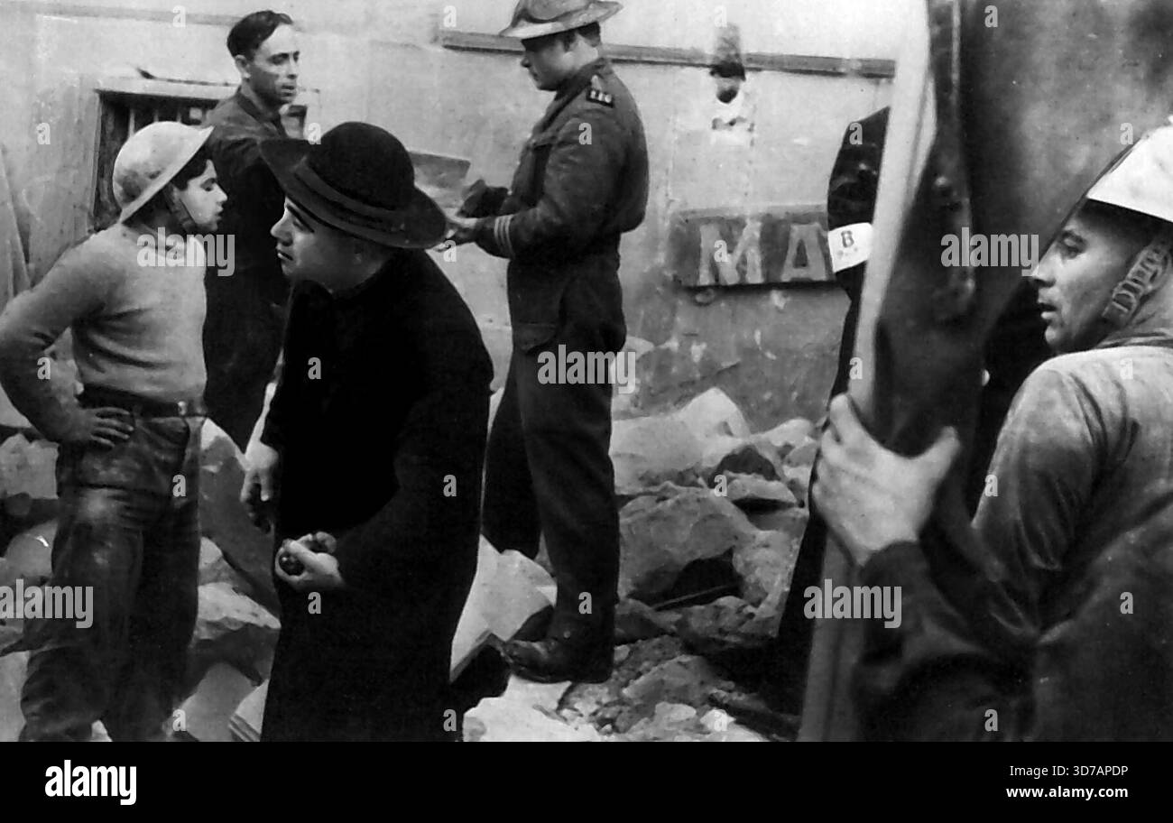 Erbarmungsarbeit -- Priester wartet inmitten der Ruinen eines neu bombardierten Hauses auf Malta auf Rettungskräfte, um Opfer zu befreien, die möglicherweise eine extreme Ausrottung der Kirche brauchen. Juni 1942. (Foto von AP Wirephoto). Stockfoto
