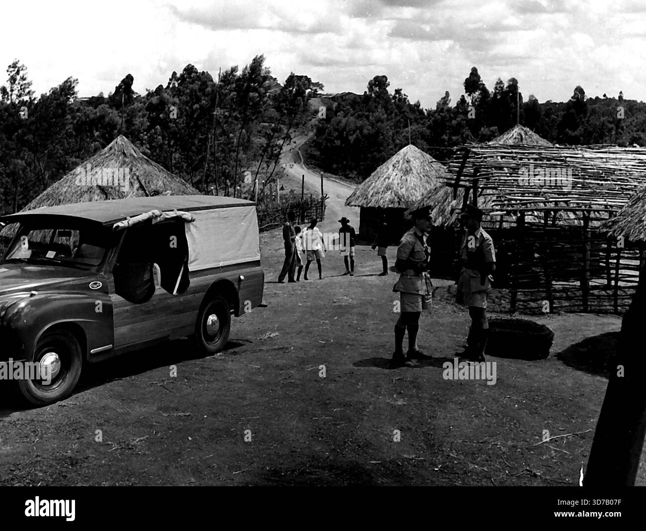 Die Stammesleute der Kikuyu bauen Einen Strong Post mit Einem Gefängnis -- die zwei jungen Polizisten, die sich auf der Stelle des Postens in der Forthalle versammeln. Ihr Personalwagen, ein leistungsstarkes, modernes Fahrzeug, steht in der Nähe. Stammesangehörige der Kikuyu bauen in Githumu einen brandneuen Polizeiposten mit Gefängnis, Anklage und Stacheldrahtzäunen - damit die kenianische Polizei Recht und Ordnung in der unruhigen Reserve aufrechterhalten kann. Die Aufgabe, die Ordnung in dem Gebiet - Standort 3 - des verwüsteten Forthalle-Reservats aufrechtzuerhalten, liegt in den Händen von zwei jungen Männern - beide in ihren Zwanzigern - und 14 afrikanischen Polizisten Askaris. Dezember, Stockfoto