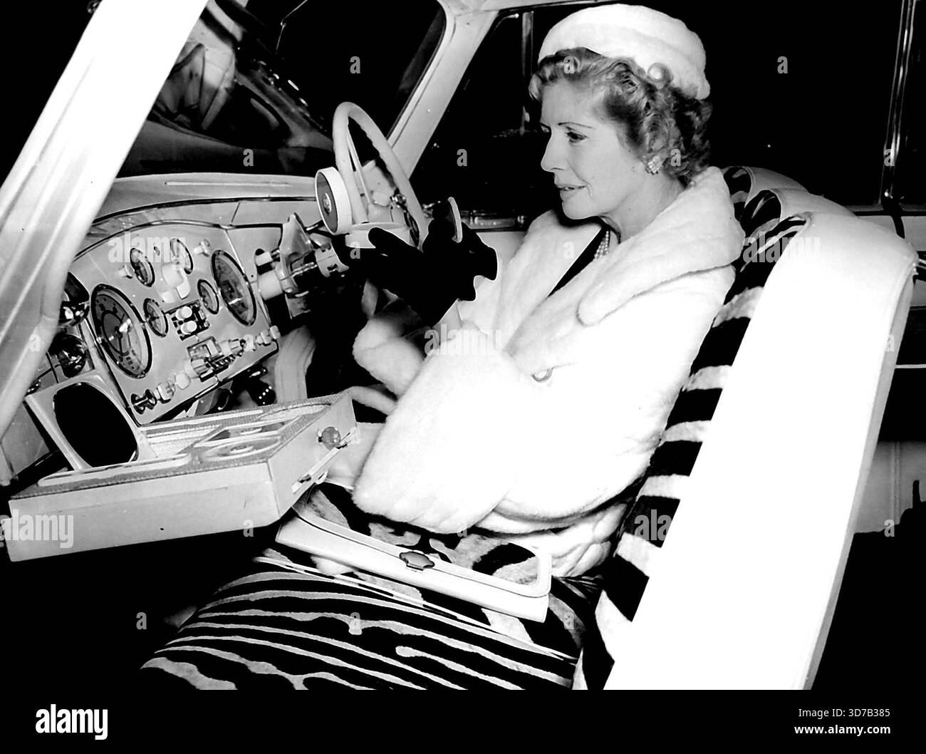 Dockers zeigen ihr neues Auto - Ein neues Auto für die Docker's, das heute auf der Motor Show in Earls Court zu sehen ist. Es ist ein Daimler DK. 400, 2-türiges Coupé mit festem Kopf, elfenbeinfarben lackiert und mit Naturhaut, elfenbeinfarbenem Leder und Nylon gepolstert. Alle inneren und äußeren Metallteile sind vergoldet. Es gibt auch Cocktail- und Picknickausrüstung sowie einen Klapptisch. Maniküre-Set usw., mit dem Lady Docker gesehen wird. Oktober 1955. Stockfoto