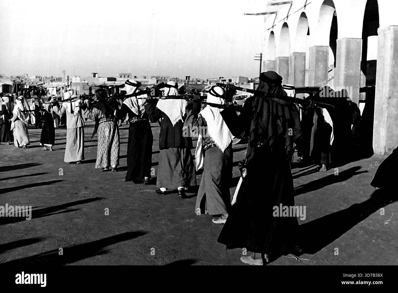 Beduinentanz in Kuwait - auf der Rückreise halten arabische Soldaten Gewehre hinter ihrem Hals. April 1949. (Foto von Pictorial Press). Stockfoto