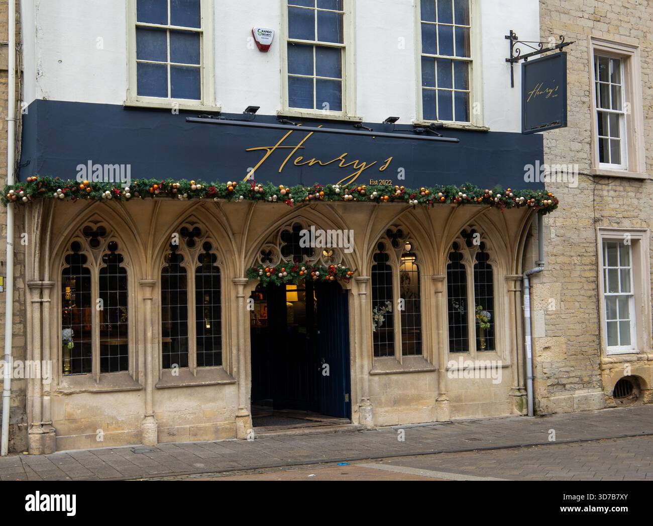Traditionelles, weihnachtlich dekoriertes Steingebäude mit Bogenfenstern und Restaurant namens Henry's Cirencester Gloucestershire UK Stockfoto