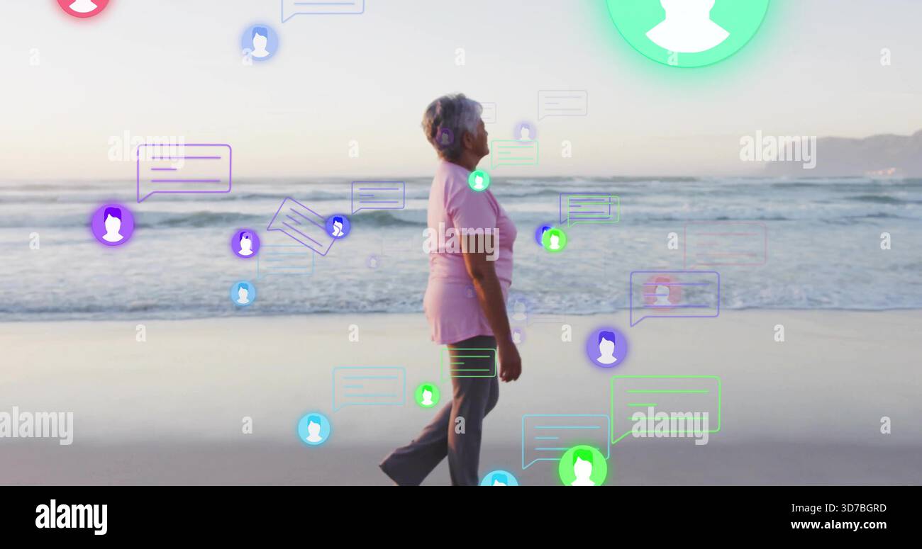 Eine ältere Frau in rosa Hemd und dunkler Hose entlang der Sandküste mit bunten Chat-Overlays Stockfoto