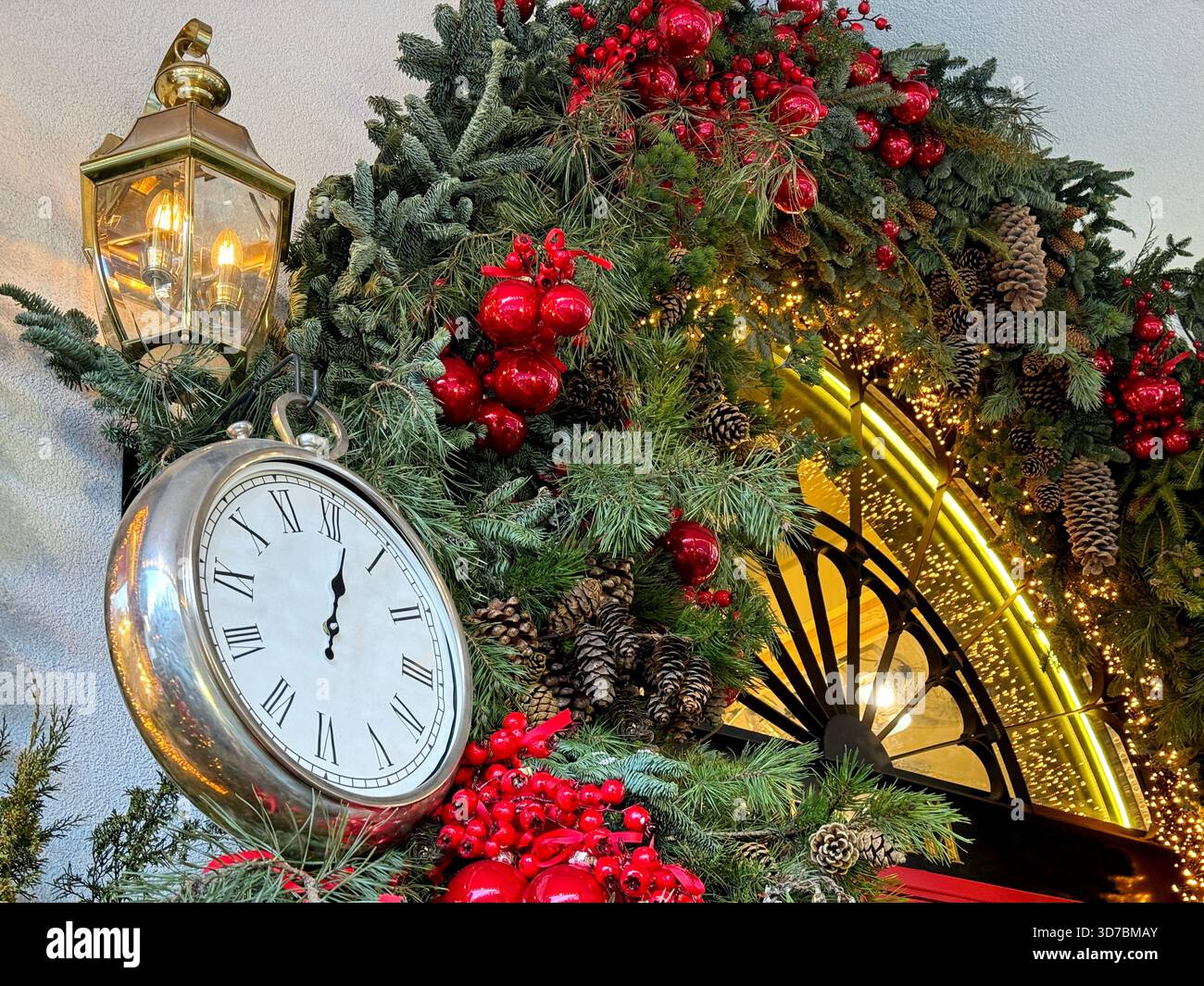 Wunderschöne Weihnachtsbaumdekoration und goldene Uhr an der Fassade Stockfoto