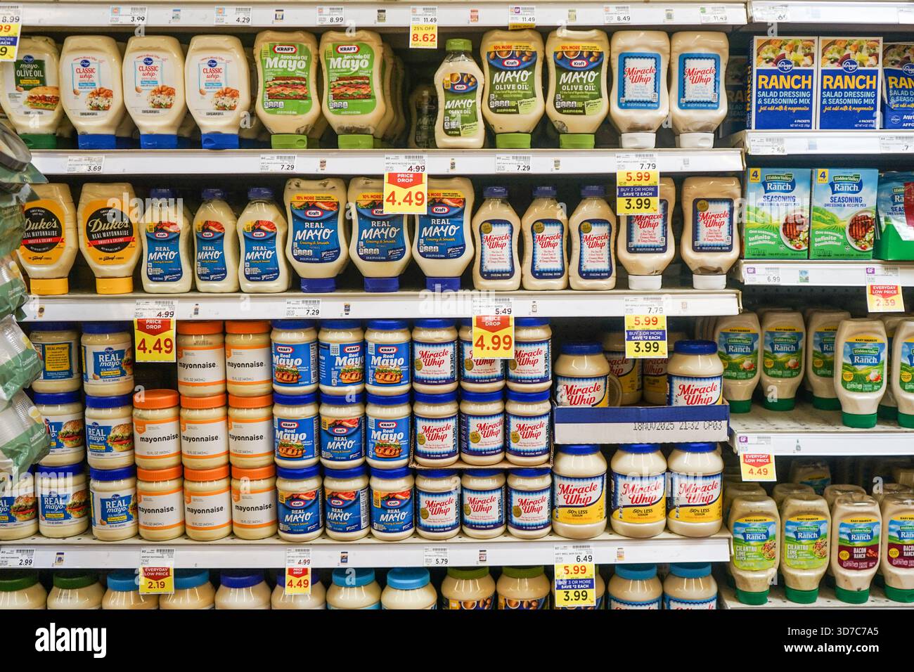 Eine Vielzahl von Typen und Marken, wie Kraft und Miracle Whip, Mayonnaise, Salatdressing und andere Gewürze in einem Regal in einem Smith's Supermarkt Stockfoto