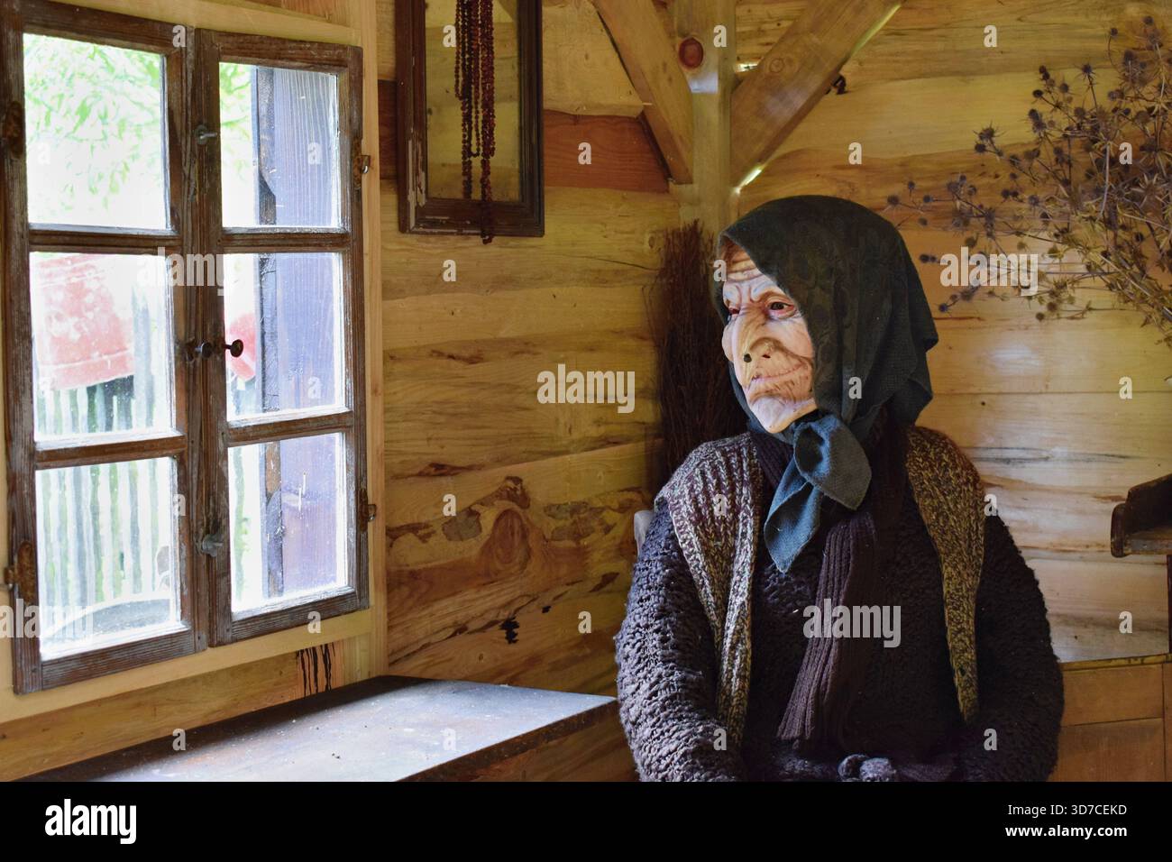 Die alte Hexenfigur sitzt in ihrem Haus Stockfoto