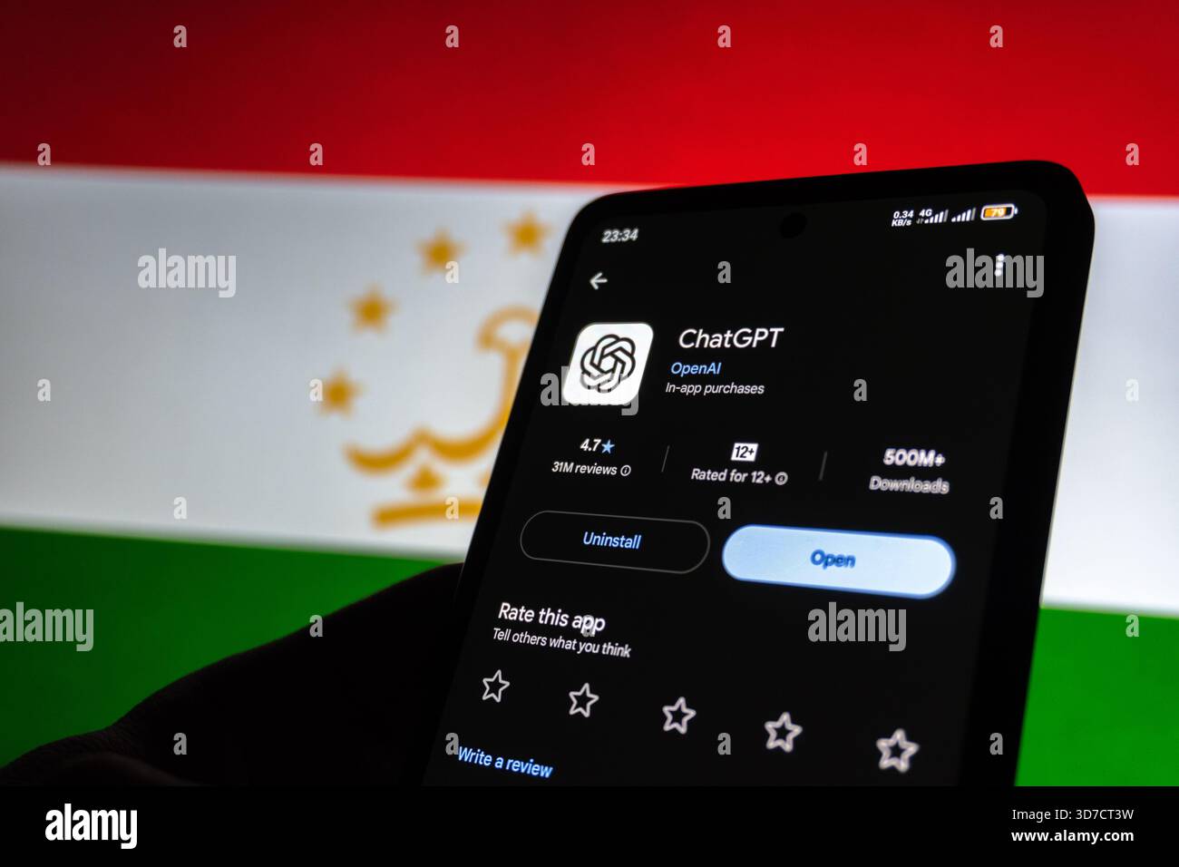 ChatGPT App auf Smartphone vor der Flagge Tadschikistans. Baku, Aserbaidschan. 11.25.2025. Stockfoto