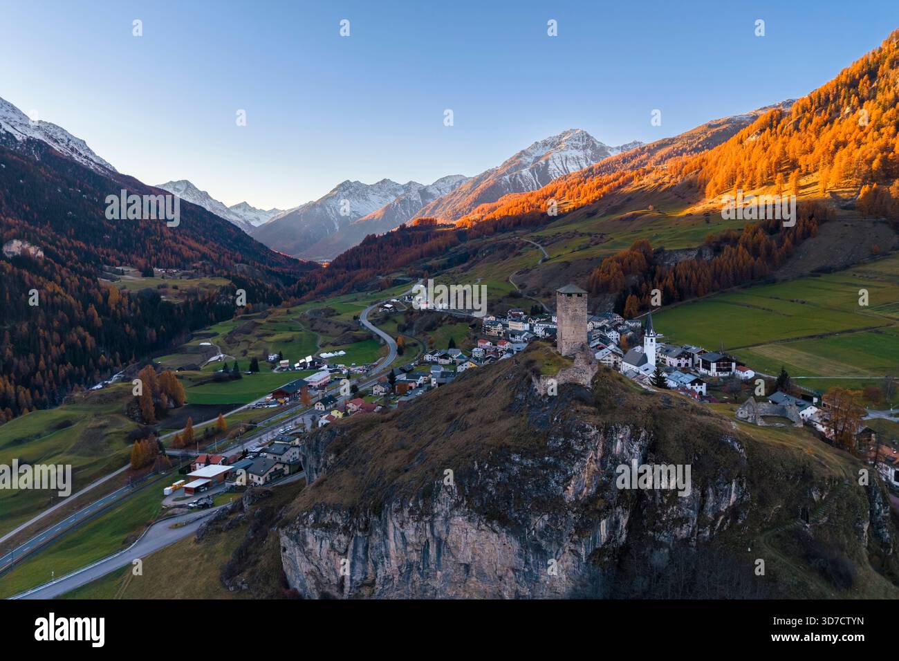Herbstlicher Sonnenuntergang auf der Stadt und mittelalterlicher Turm von Ardez bei Sonnenuntergang. Scuol, Kanton Graubünden, Bezirk Inn, Unterengadin, Schweiz, Europa. Stockfoto
