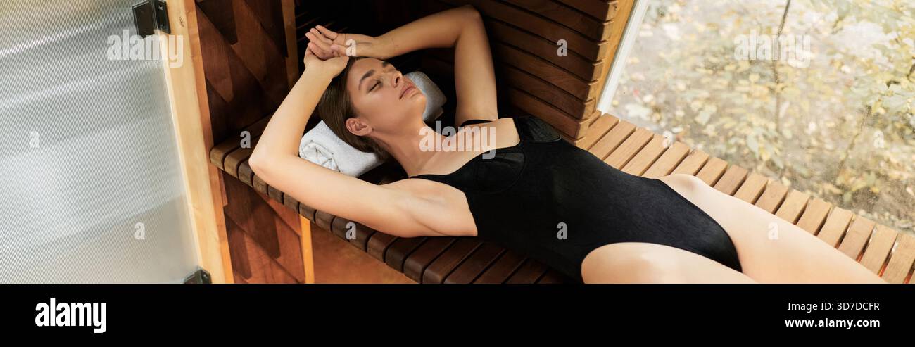 Eine schöne junge Frau genießt ihre Zeit in der Sauna, genießt Entspannung und Ruhe, Banner Stockfoto